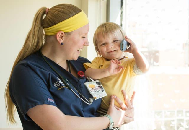 a nurse holds a little girl